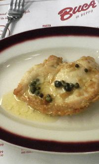 two pieces of food sitting on top of a white and red plate next to a fork