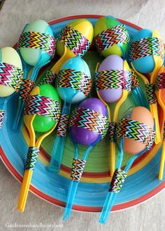 there are many colorful spoons on the plate with eggs in them and one is yellow