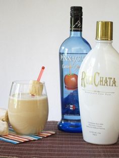 two bottles of rumchata next to a glass filled with ice and cinnamon sticks