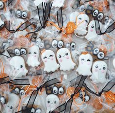 halloween cookies decorated like ghostes and bats in cellophane bags with orange string