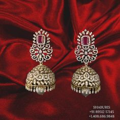 an image of a pair of earrings on a red cloth