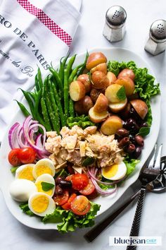 a white plate topped with salad and eggs