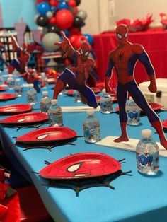 the table is set with spiderman paper plates and water bottles