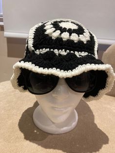 a black and white crocheted hat on top of a mannequin head