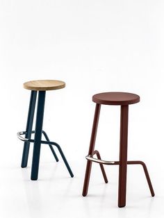 two stools sitting next to each other in front of a white wall and floor