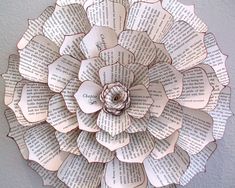 an origami flower made out of old book pages is displayed on the wall