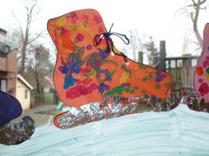 two colorful kites are being flown in the air with snow on them and one is upside down