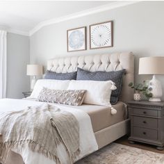 a bedroom with a bed, nightstands and two pictures on the wall above it