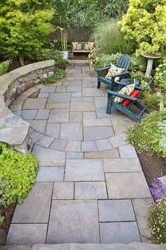 an outdoor patio with two chairs and stone walkway leading up to the back yard area