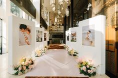 an indoor wedding venue with flowers and pictures on the wall