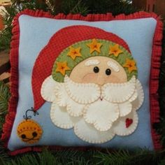 a christmas pillow with a santa clause on it and a ladybug hanging from the tree