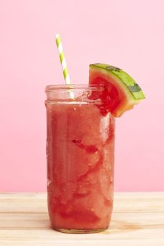 a watermelon drink in a mason jar with a striped straw