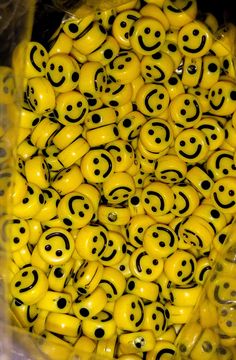 there are many yellow smiley faces in the plastic bag that is filled with eyes and smiles