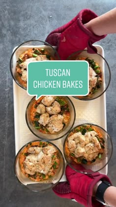 a person in red gloves is holding a tray with four bowls of food and the words tuscan chicken bakes above it