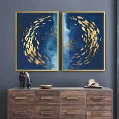 two paintings are hanging on the wall above a dresser in a room with blue walls