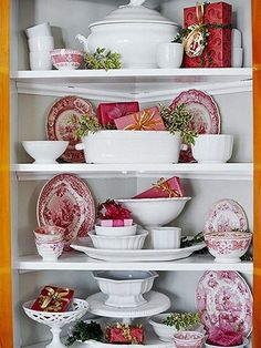 the china cabinet is filled with dishes and gifts for christmas time or any special occasion