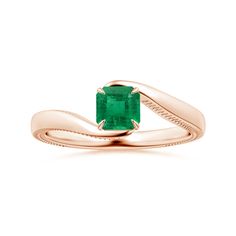 a gold ring with an emerald stone in the center and a twisted band around it