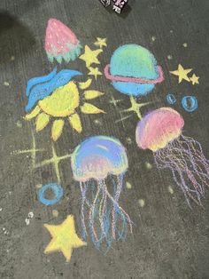 some chalk drawings on the ground with stars and jellyfish