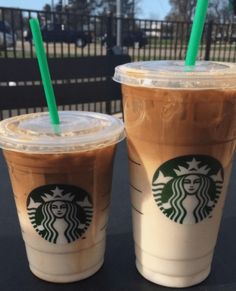 two starbucks drinks sitting next to each other on a table