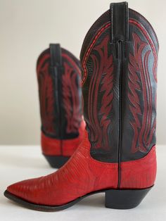 Tegu lizard and leather cowboy boots with a walking heel and dressy snip-toe. The black leather shaft is smooth, slightly textured, and beautifully embroidered in red. Leather soles and stacked leather heels. Justin is a high-quality bootmaker: these are sturdy and welted for a lifetime of resoling. Made in U. S.A.Size: 6. 5 (women) / 5 (men)Shaft: 11”Heel: 1. 5”Heel to toe: 10. 25”The toe box, across widest point: 3. 25�”Condition: excellent, regular scuffing and wear on the bottomNeed to know: Tegu Lizard, 70s Boots, Snakeskin Cowboy Boots, Custom Cowboy Boots, Pirate Boots, Silverado Truck, Leather Cowgirl Boots, Leather Western Boots, Harness Boots