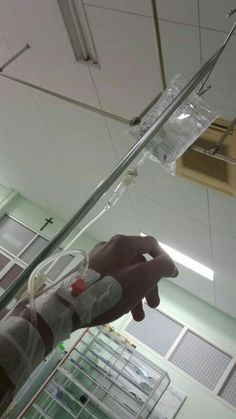 a person holding something in their hand with an iv attached to the end of it