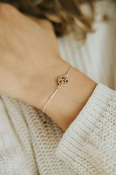 a woman wearing a bracelet with a flower on it