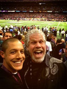 two men standing next to each other at a football game