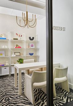 the interior of a modern office with zebra print carpeting and white furniture, along with shelving units