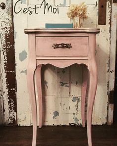 an old pink table with a vase on top and the words cest moit above it