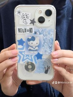 a person holding up a cell phone case that has pictures on it and stickers on the back