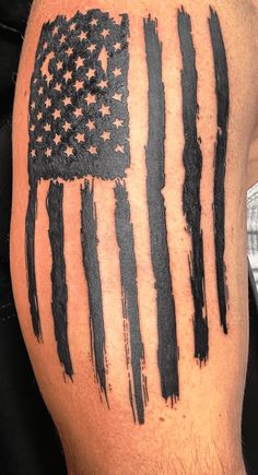 an american flag painted on the back of a man's leg with black ink