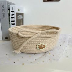 a white basket with a dog paw on the side and a book in the background