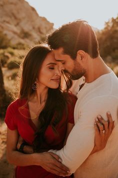 a man and woman embracing each other in the desert