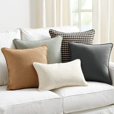 a white couch with four different colored pillows on it