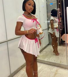 a woman standing in front of a mirror holding a cupcake and looking into the camera