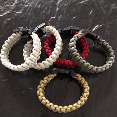 four different colored bracelets sitting on top of a black table next to each other