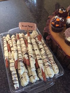 there are many desserts in the tray on the counter top, including cupcakes