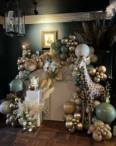 a giraffe is standing in front of some balloons and decorations on the wall