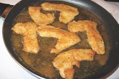 some chicken is cooking in a pan on the stove