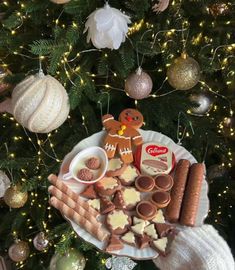 a christmas tree is decorated with cookies, crackers and other holiday treats on a plate