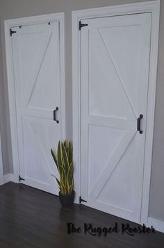 two white doors with plants in them on a wooden floor next to the door and wall