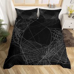 black and white bedding with spider webs on the bottom, in a bedroom