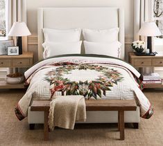 a bed with a white comforter and two lamps on either side of the bed