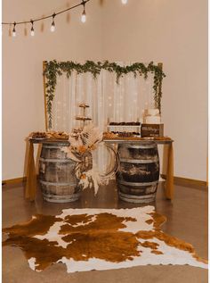 a table with two wine barrels on top of it and a cowhide rug in front of it