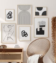 a white room with many black and white pictures on the wall, including a wicker chair