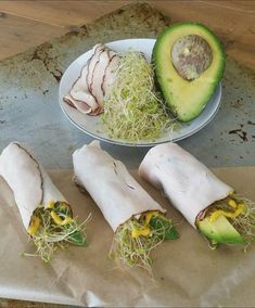 some food is laying out on a table next to a bowl and an avocado