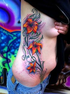 a woman's stomach with flowers and vines on the side, in front of a colorful background