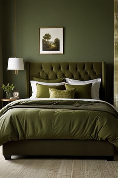 a bed with green sheets and pillows in a bedroom next to a painting on the wall