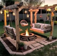 an outdoor fire pit with swings and chairs