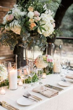 the table is set with many glasses and place settings for guests to sit down at